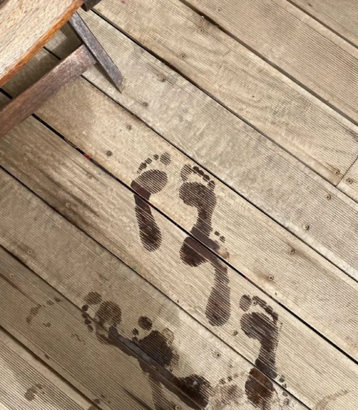 Wet bare footprints on a wooden dock